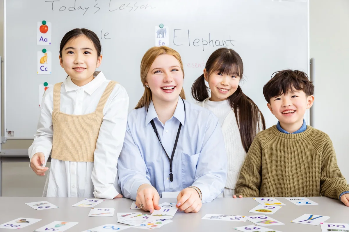 先生と一緒に英語のカードで学ぶ子どもたち